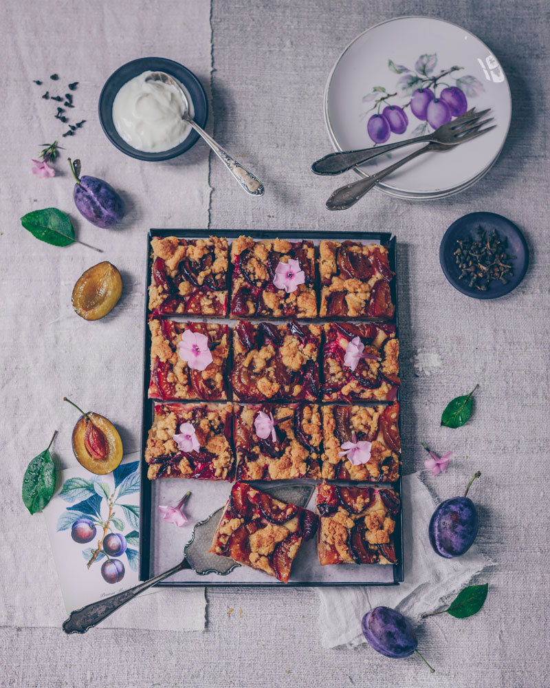 Zwetschgenkuchen mit Zimtblüten auf dunklem Untergrund